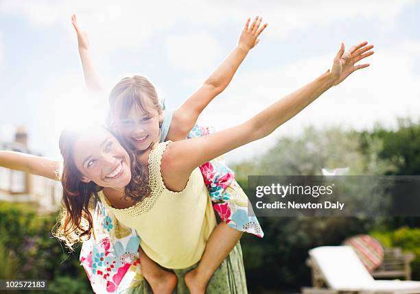 mother and daughter (8-9) playing in garden - human arm stock pictures, royalty-free photos & images