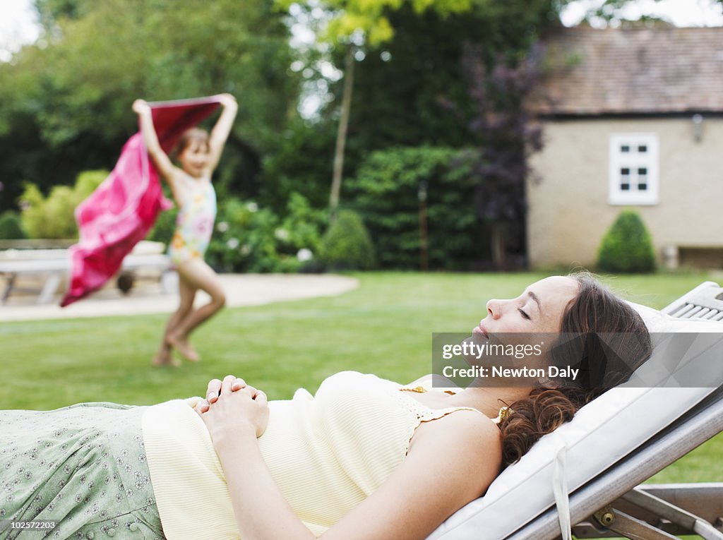 Mother and daughter (8-9) relaxing in garden