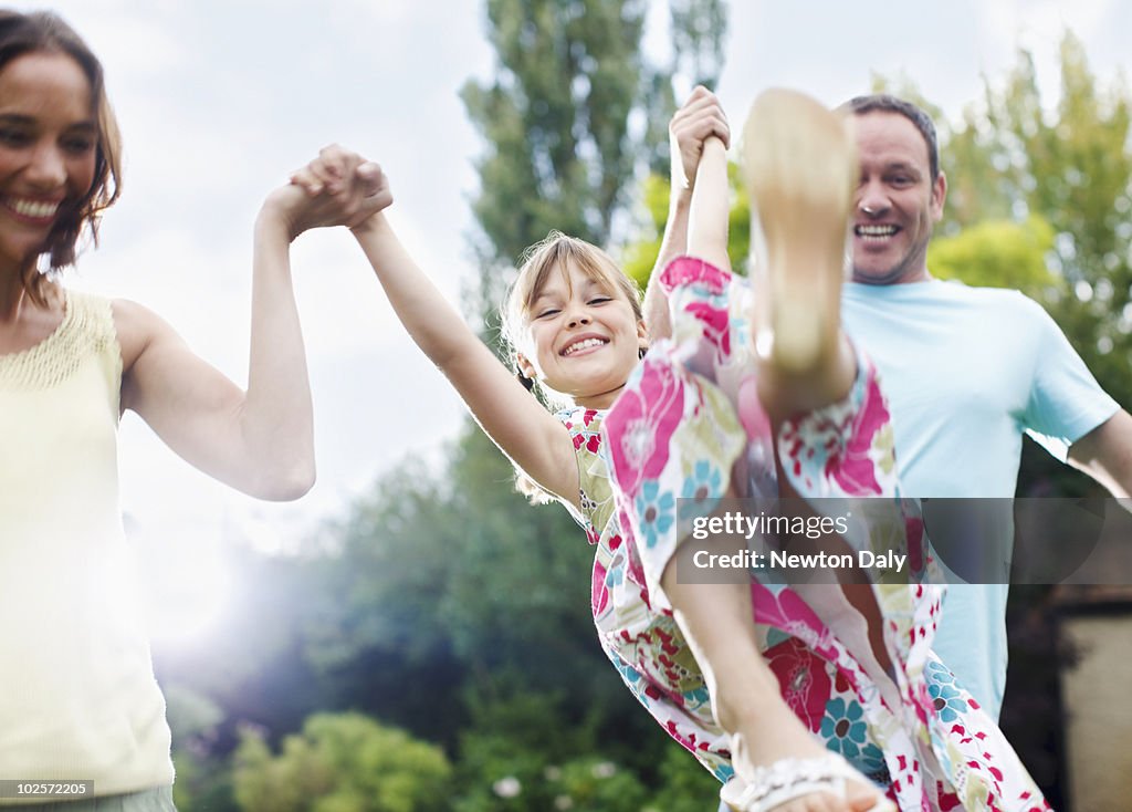 Couple playing with daughter (8-9) in garden