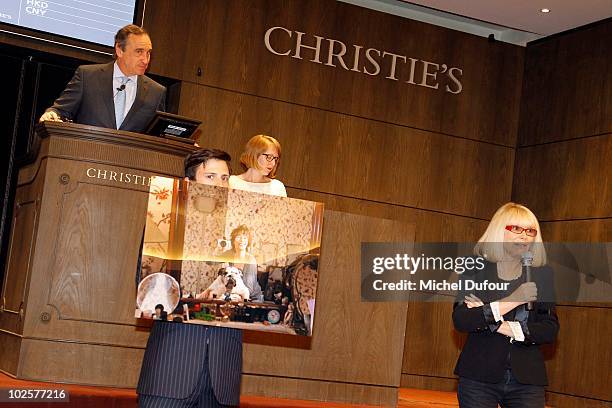 Christie's employee holds a photograph of Jane Birkin during the auction at Christie's for Association Chaine de l'Espoir on July 1, 2010 in Paris,...