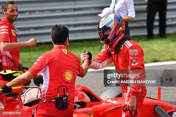 Ferrari's Finnish driver Kimi Raikkonen celebrates winning the pole position with team members after the qualifying session at the Autodromo...