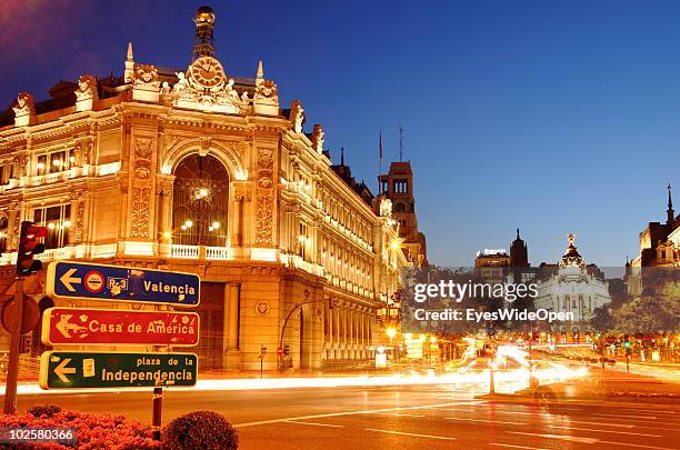 Traffic drives past the Banco Espagna building next to Plaza Cibeles at night. The Metropolis building in the background is at the famous boulevard...