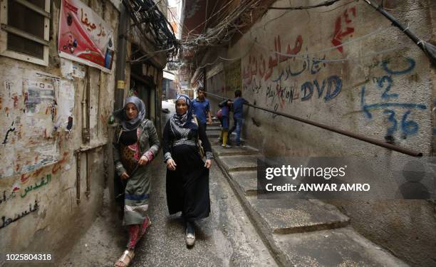 Women walk in a street in the Palestinian refugee camp Burj al-Barajneh, south of the capital Beirut, on September 1, 2018. Palestinians reacted...