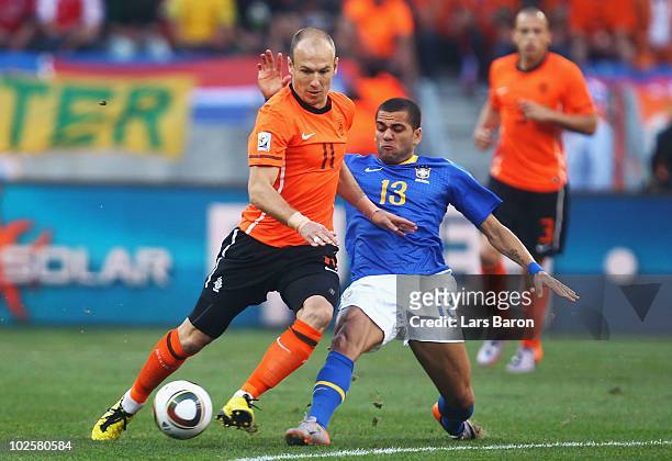 Dani Alves of Brazil tackles Arjen Robben of the Netherlands during the 2010 FIFA World Cup South Africa Quarter Final match between Netherlands and...