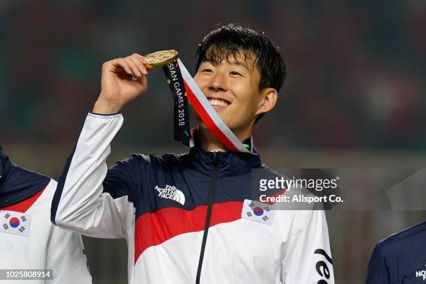 Son Heung Min of South Korea rises his gold medal after defeating Japan 2-1 in extra time during the Men's Football gold medal match between South...