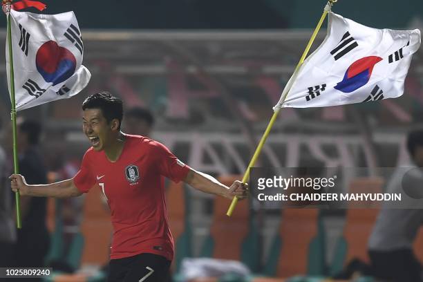 South Korea's forward Heung Min Son celebrates after defeating Japan during the men's football gold medal match at the 2018 Asian Games in Bogor on...