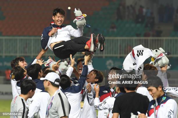South Korea's players toss their teammate Son Heung-min in the air after the victory ceremony for the mens football competition at the 2018 Asian...