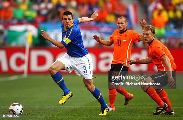 Lucio of Brazil is challenged by Dirk Kuyt and Wesley Sneijder of the Netherlands during the 2010 FIFA World Cup South Africa Quarter Final match...