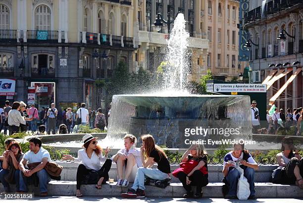 Tourists and locals sitting next to a fountain at Puerta del Sol on May 20, 2010 in Madrid, Spain. Madrid is a big european city with more than 3...
