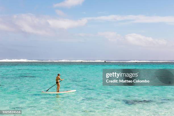 woman paddleboarding in rarotonga, cook islands - rarotonga fotografías e imágenes de stock