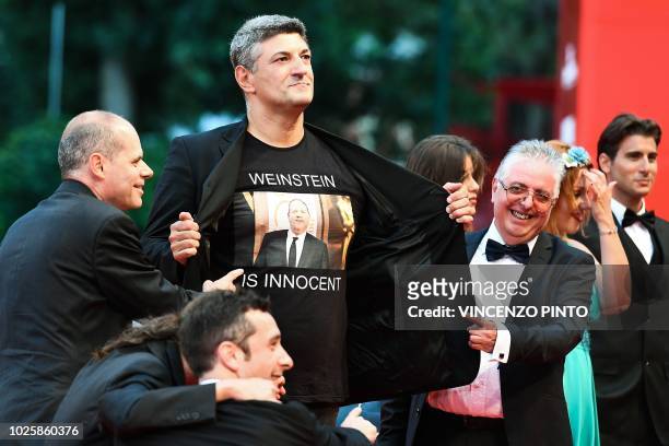 Italian director Luciano Silighini Garagnani flashes a jersey reading "Weinstein is innocent" as he arrives for the premiere of the film "Suspiria"...