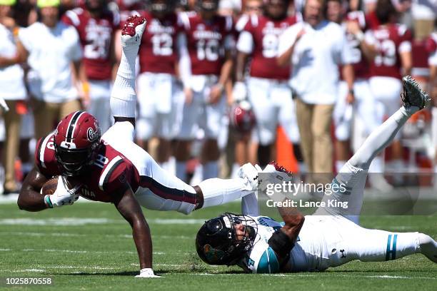 OrTre Smith of the South Carolina Gamecocks dives for extra yardage against Preston Carey of the Coastal Carolina Chanticleers at Williams-Brice...