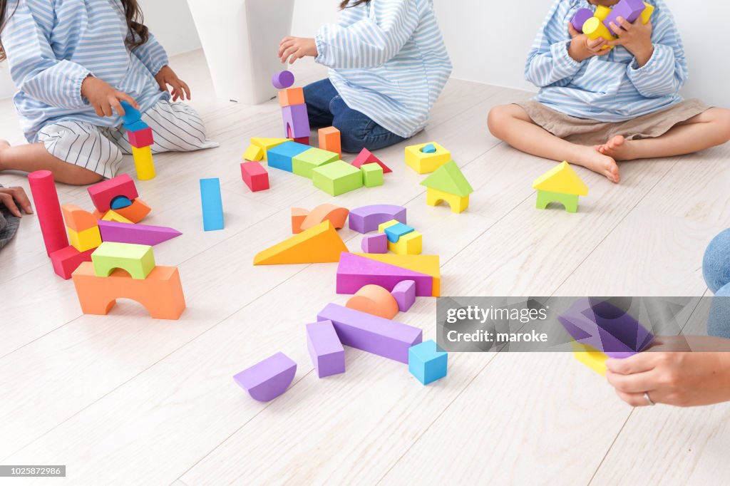 Children  and teacher playing with toy
