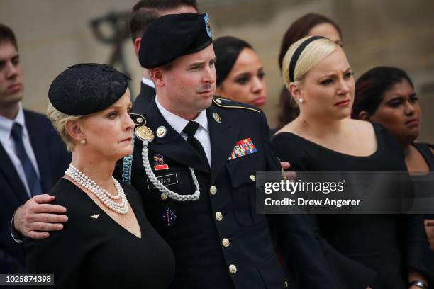 Cindy McCain, her son James McCain, daughter Meghan McCain, and Bridget McCain look on as the casket of the late Senator John McCain is loaded into a...