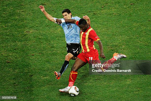Maximiliano Pereira of Uruguay defends a cross from Sulley Muntari of Ghana during the 2010 FIFA World Cup South Africa Quarter Final match between...