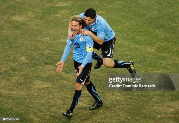 Luis Suarez celebrates with Diego Forlan of Uruguay celebrates after he scored his team's first goal from a free kick during the 2010 FIFA World Cup...