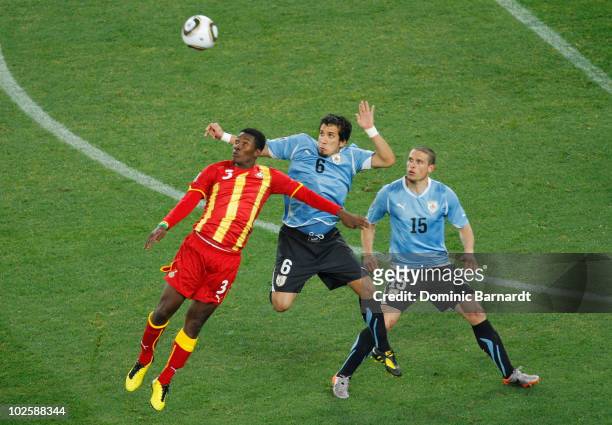 Asamoah Gyan of Ghana, Mauricio Victorino and Diego Perez of Uruguay challenge for the ball during the 2010 FIFA World Cup South Africa Quarter Final...