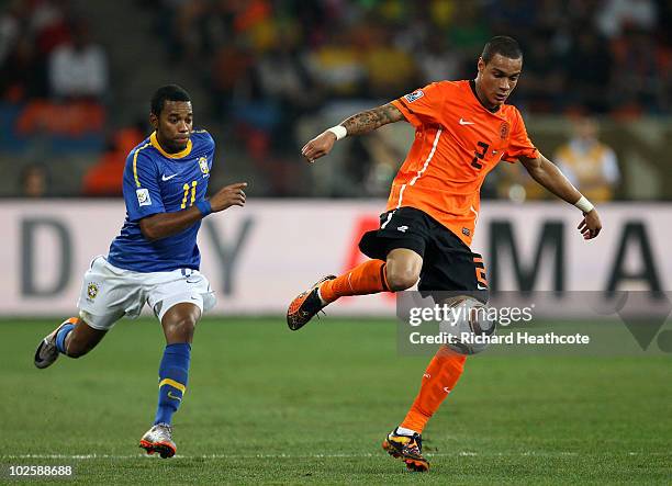 Gregory Van Der Wiel of the Netherlands holds off Robinho of Brazil during the 2010 FIFA World Cup South Africa Quarter Final match between...