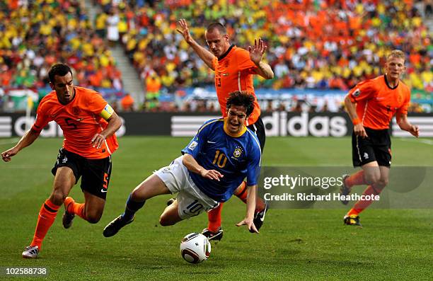 Kaka of Brazil is brought down by Giovanni Van Bronckhorst and Andre Ooijer of The Netherlands during the 2010 FIFA World Cup South Africa Quarter...