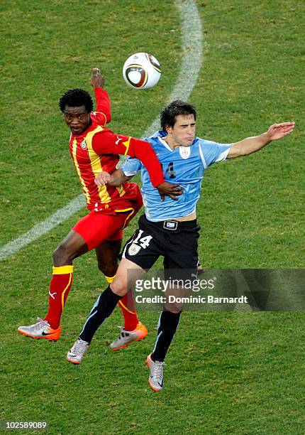 Anthony Annan of Ghana and Nicolas Lodeiro of Uruguay battle for a high ball during the 2010 FIFA World Cup South Africa Quarter Final match between...
