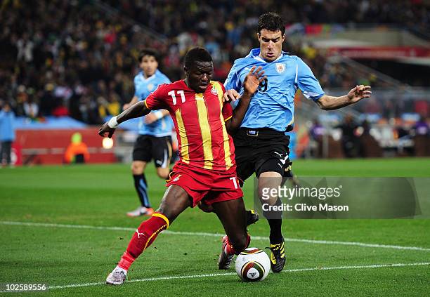 Andres Scotti of Uruguay challenges Sulley Muntari of Ghana during the 2010 FIFA World Cup South Africa Quarter Final match between Uruguay and Ghana...