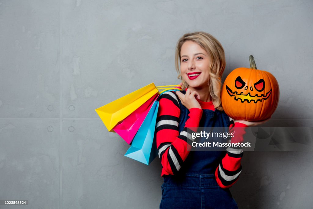 Girl with shopping bags and halloween pumpkin