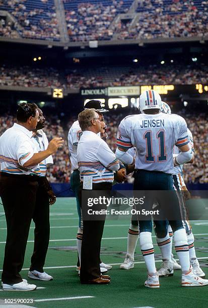 Head Coach Don Shula of the Miami Dolphins in this portrait on the sidelines talking with quarterback Dan Marino and quarterback/wide receiver Jim...