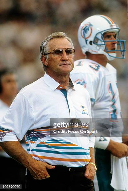 Head Coach Don Shula of the Miami Dolphins in this portrait standing next to quarterback Dan Marino watching the action from the sidelines circa...