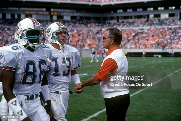 Head Coach Don Shula of the Miami Dolphins in this portrait on the sidelines greats quarterback Dan Marino and wide receiver Fred Banks coming off...