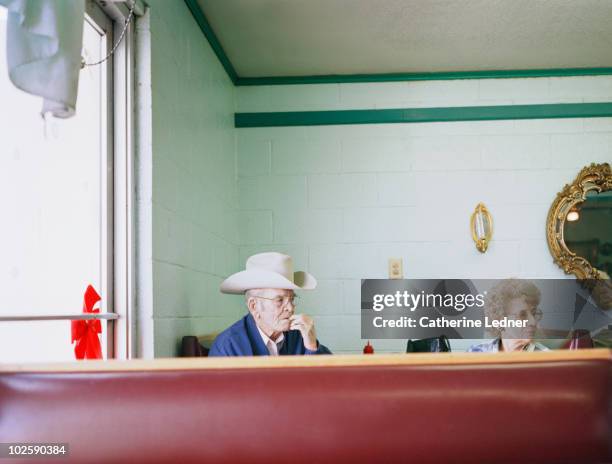 elderly couple sitting in a diner. - diner foto e immagini stock