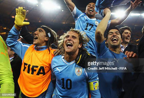 Diego Forlan , Egidio Arevalo , Luis Suarez of Uruguay and team mates celebrate winning the penalty shoot out and progress to the semi finals during...