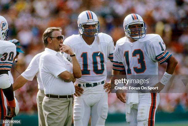 Head Coach Don Shula of the Miami Dolphins in this portrait on the sidelines talking with quarterbacks Dan Marino and Don Strock circa mid 1980's...