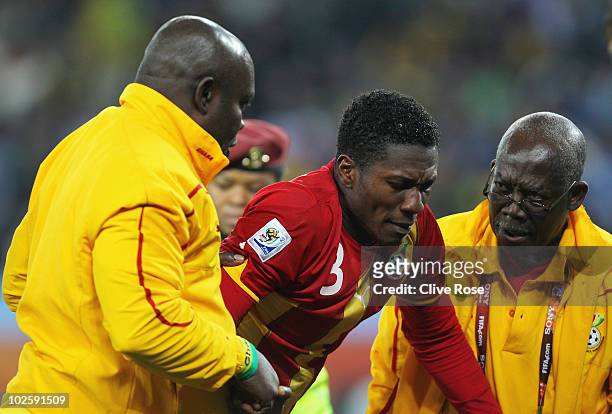 Asamoah Gyan of Ghana is consoled after his team are knocked out in a penalty shoot out during the 2010 FIFA World Cup South Africa Quarter Final...