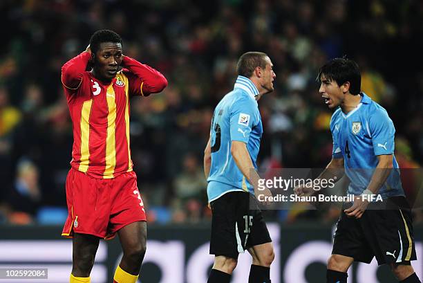 Asamoah Gyan of Ghana holds his head in shock after he hits a penalty kick onto the crossbar after Luis Suarez of Uruguay handles the ball off the...