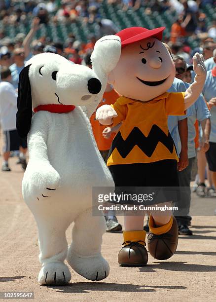 Snoopy and Charlie Brown from the Peanuts Gang wave to the crowd during the Peanuts 60th Anniversary celebration before the game between the Detroit...