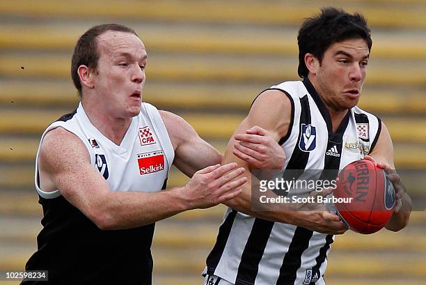 Paul Medhurst of Collingwood is tackled by Stephen Clifton of North Ballarat during the round 11 VFL match between Collingwood and North Ballarat at...