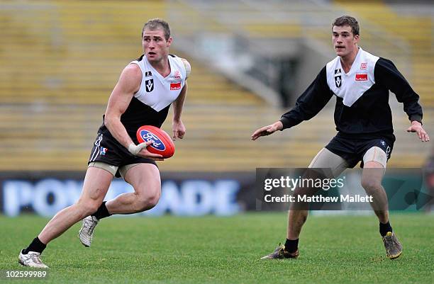 Luke Delaney of North Ballarat looks to handball during the round 11 VFL match between Collingwood and North Ballarat at Victoria Park on July 3,...