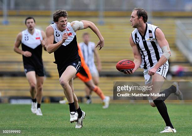 Josh Fraser of Collingwood handballs during the round 11 VFL match between Collingwood and North Ballarat at Victoria Park on July 3, 2010 in...