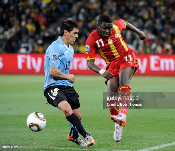 Sulley Muntari of Ghana kicks the ball past Maximiliano Pereira of Uruguay during the 2010 FIFA World Cup South Africa Quarter Final match between...