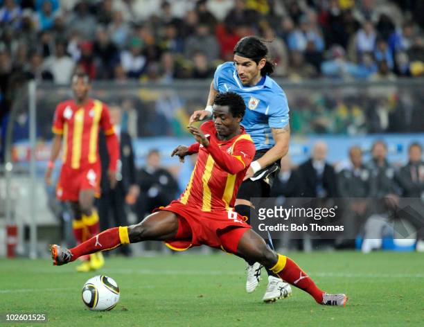 Anthony Annan of Ghana is challenged by Sebastian Abreu of Uruguay during the 2010 FIFA World Cup South Africa Quarter Final match between Uruguay...