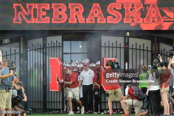 Head coach Scott Frost of the Nebraska Cornhuskers leads the team on the field before the game against the Akron Zips at Memorial Stadium on...