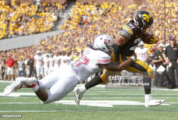 Runningback Ivory Kelly-Martin of the Iowa Hawkeyes runs up the field for a touchdown during the second half against linebacker Kyle Pugh of the...