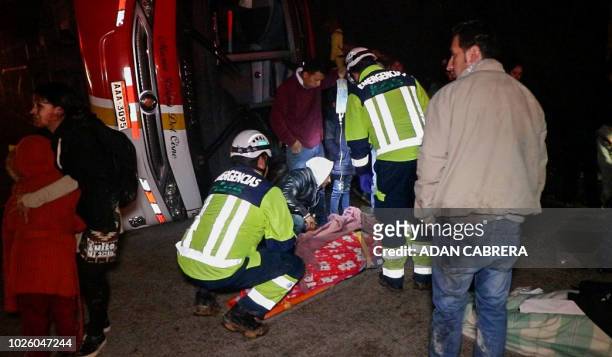Firefighters and rescuers work at the scene of an accident where a bus overturned and crashed in the Cuenca - Loja route, 21 kilometers south of the...