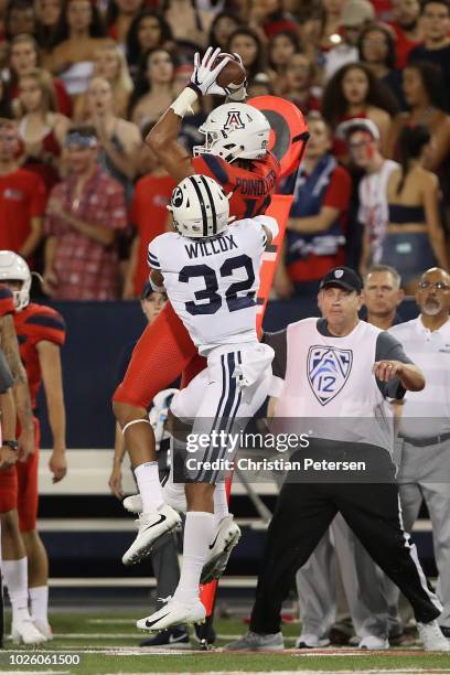 Wide receiver Shawn Poindexter of the Arizona Wildcats mkes a leaping catch over defensive back Chris Wilcox of the Brigham Young Cougars during the...