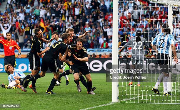 The Germany team celebrate with Arne Friedrich after he scores his team's third goal during the 2010 FIFA World Cup South Africa Quarter Final match...