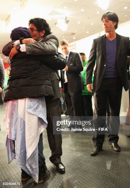 Diego Maradona head coach of Argentina embraces his daughter Dalma as Joachim Loew head coach of Germany looks on after the 2010 FIFA World Cup South...