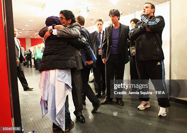 Diego Maradona head coach of Argentina embraces his daughter Dalma as Joachim Loew head coach of Germany looks on after the 2010 FIFA World Cup South...