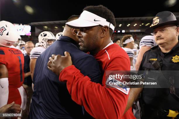 Head coaches Kevin Sumlin of the Arizona Wildcats and Kalani Sitake of the Brigham Young Cougars shake hands following the college football game at...