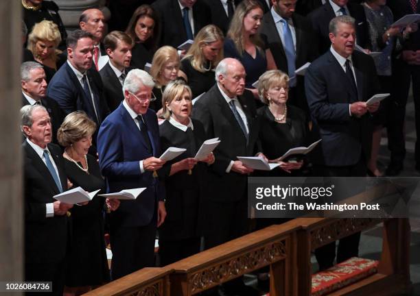 Presidents George Bush and Bill Clinton sign the opening hmm with their wives during the funeral service at the National Cathedral for Sen. John S....