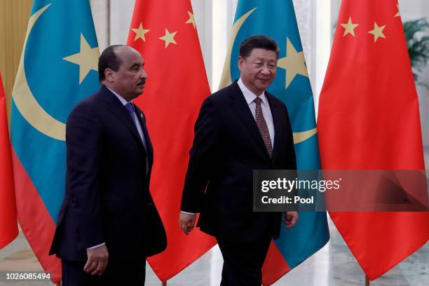 Mauritania's President Mohamed Ould Abdel Aziz, left, walks with Chinese President Xi Jinping as they proceed to their bilateral meeting at the Great...